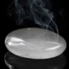 Quartz transparent – galet poli Galet de quartz transparent poli sur fond noir avec fumée