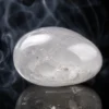 Quartz transparent – pierre polie Pierre de quartz transparent polie sur fond sombre avec reflet