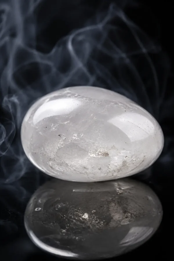 Quartz transparent – pierre polie Pierre de quartz transparent polie sur fond sombre avec reflet