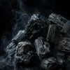 Tourmaline noire brute – lot de pierres Plusieurs pierres de tourmaline noire brute groupées sur fond noir avec fumée