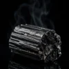 Tourmaline noire brute – pièce unique Pierre de tourmaline noire brute posée sur fond noir brillant