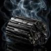 Tourmaline noire brute – pierre brute sur fond fumé Pierre de tourmaline noire brute avec fumée sur fond sombre